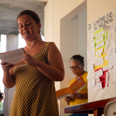 Isabel Iturralde holds a booklet as she teaches a class on violence against women