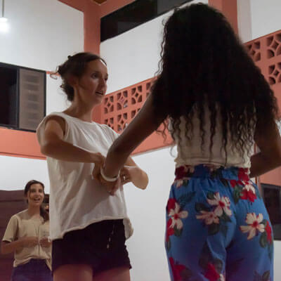 Isabel Rocha holds one of her students hands to her abdomen to demonstrate breathing techniques during her voice lesson